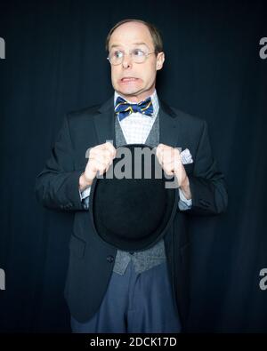 Portrait of Fcid man in Vintage Clothes Halten Bowler Hut mit einem nervösen Ausdruck. Klassischer und exzentrischer englischer Gentleman. Stockfoto