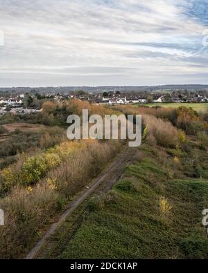 Eine eingleisige Eisenbahnlinie verläuft auf einem überwucherten Damm von der Portishead Railway zum Royal Portbury Dock in pill in North Somerset. Stockfoto