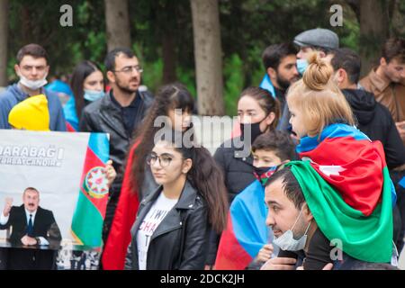 Ein Mädchen wickelte die aserbaidschanische Flagge auf die Schulter seines Vaters und sie feiern den Siegestag des Karabach-Krieges. Baku - Aserbaidschan: 10. November 2020. Stockfoto