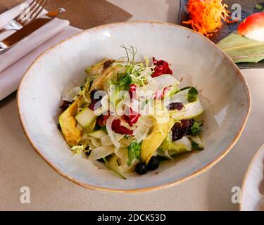 Frische Gemüsesalatschüssel mit Spargel, Fenchel, Avocado, Rosinen und Salat mischen Stockfoto