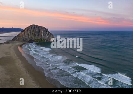 Im Morgengrauen trifft der Pazifik auf die berühmte Küste von Morro Bay, Kalifornien. Dieser Teil von Zentralkalifornien ist bekannt für seine wunderschöne Küste. Stockfoto