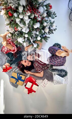 Ein schönes Paar genießt auf dem Boden liegen mit Weihnachtsgeschenke an einem schönen Urlaub Morgen. Weihnachten, Beziehung, Liebe, zusammen Stockfoto