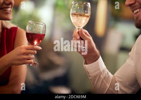 Ein junges verliebtes Paar, das einen Drink bei der Valentinstag-Feier in entspannter Atmosphäre in einem Restaurant hat. Zusammen, Valentinstag, Feier Stockfoto