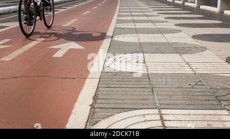 Radler Schatten auf Fahrrad rote Spur neben Fußgänger Bürgersteig an der Küste in Las Palmas, Spanien. Outdoor-Aktivität, gesunde Lifestyle-Konzepte Stockfoto