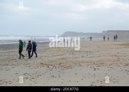 Winterwochenende Spaziergänger, Outdoor-Training am Happisburgh Strand und an der Küste. Soziale Distanzierung wird respektiert. Norfolk. VEREINIGTES KÖNIGREICH. Stockfoto