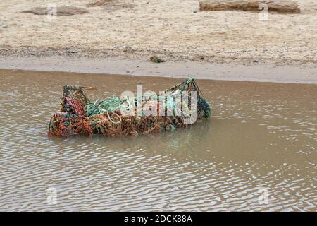 Fischernetz, Hummer Töpfe, Seile, - Plastik, Metall, alle zusammen, gewaschen bis auf Happisburgh Strand und Küste, Gezeiten gebracht. Echte Augenmuschel, Stockfoto