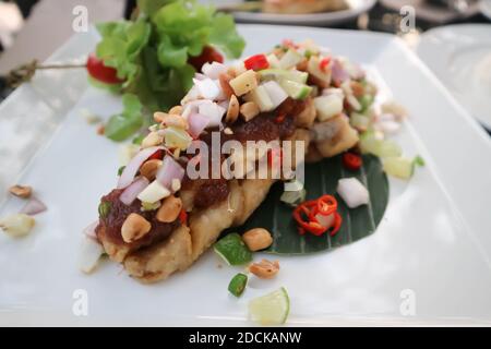 Gegrillter Bass und Gemüse, gegrillter Fisch mit würzigem Dressing Stockfoto