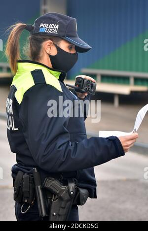 Vendrell, Spanien. November 2020. Ein Polizist mit Gesichtsmaske bestätigt die Identifizierung eines Fahrers an einem Kontrollpunkt.in der dritten Woche der Coronavirus-Einschränkungen, die lokale Polizei von Vendrell (Spanien), nach den Anweisungen der Regierung von Katalonien, Intensiviert die Kontrollpunkte zur Überwachung der Perimetermobilität innerhalb der Gemeinde aufgrund der in der Krise der Covid19-Pandemie zu befolgenden Regeln. Kredit: SOPA Images Limited/Alamy Live Nachrichten Stockfoto