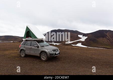 Geländewagen mit Dachzelt auf kargem Plateau, vulkanische Landschaft mit Schneefeldern, Snaefellsjoekull, Snaefellsjoekull, Snaefellsnes Halbinsel Stockfoto