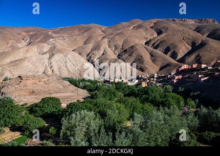 Berge, erodierte Landschaft mit Flussoase und kleines Dorf im oberen Dades-Tal, Oued Dades bei Msemrir, hoher Atlas, Süd-Marokko, Marokko Stockfoto