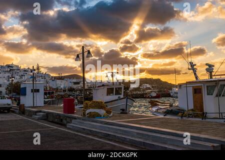 Traditionelle kykladitische Aussicht mit traditionellen Fischerbooten, die bei einem herrlichen Sonnenuntergang auf dem malerischen Hafen von Naousa Paros, Griechenland, festgemacht werden. Stockfoto