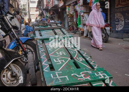 Der Handwagen eines Portiers in Mumbai, Indien, verziert mit Hakenkreuzen, dem Hindu-Symbol des Glücks (unten auf dem Bild: Das heilige Aum / OM-Symbol Stockfoto
