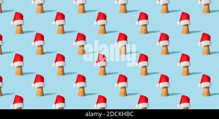 S weihnachtliche Nahtloses Muster mit Eiscreme con und Santanhat auf hellblauem Hintergrund, bunner Stockfoto