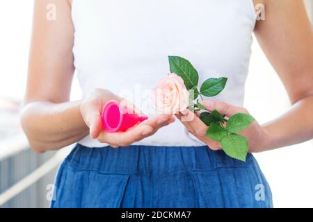 Junge Frau hält rosa Menstruationstasse Stockfoto