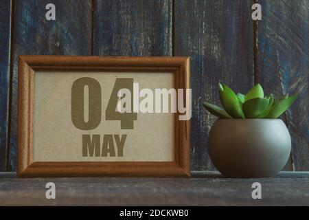Mai 4th. Tag 4 des Monats, Datum im Rahmen neben Sukkulente auf hölzernen Hintergrund Frühlingsmonat, Tag des Jahres Konzept Stockfoto