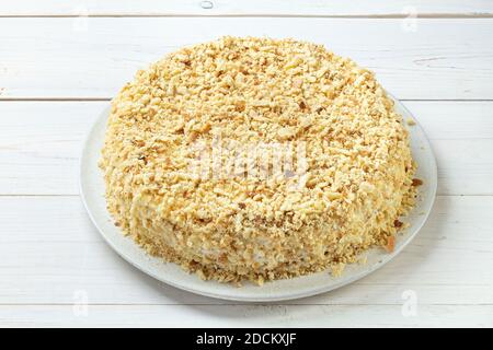 Hausgemachter Honigkuchen mit Sauerrahm auf einem weißen Holztisch. Leerzeichen für Text. Draufsicht. Stockfoto