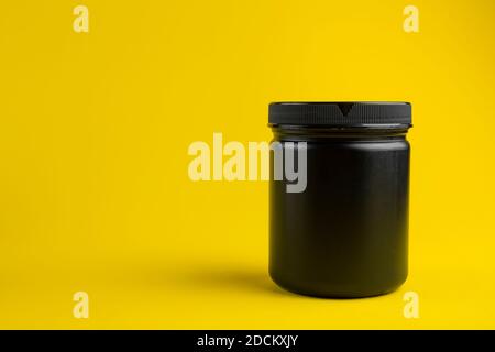 Kosmetikbehälter Mockup. Glas oder leere Verpackung für kosmetische Produkte mit Kappe auf gelbem Hintergrund. Beauty-Produkte für die Körperpflege. Platz für Punkt Stockfoto