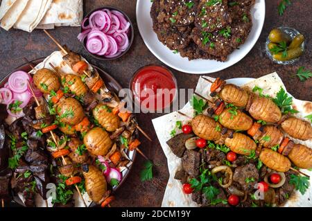 Verschiedene Gerichte Leberkebab. Spieße Leber, Vollgemüse und Pilze auf Spieße. Speisekarte vom Grill-Restaurant. Georgische, asiatische Küche. Flach liegend. Stockfoto