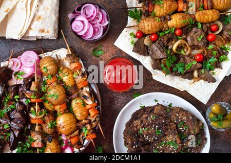 Verschiedene Gerichte Leberkebab. Spieße Leber, Vollgemüse und Pilze auf Spieße. Speisekarte vom Grill-Restaurant. Georgische, asiatische Küche. Flach liegend. Stockfoto