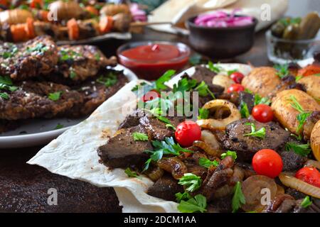 Spieße Leber, Vollgemüse und Pilze auf Spieße. Speisekarte vom Grill-Restaurant. Georgische, asiatische Küche. Verschiedene Gerichte Leberkebab. Stockfoto