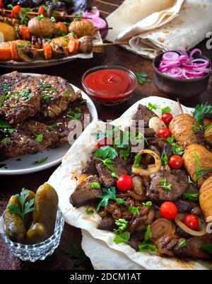 Spieße Leber, Vollgemüse und Pilze auf Spieße. Speisekarte vom Grill-Restaurant. Georgische, asiatische Küche. Verschiedene Gerichte Leberkebab. Stockfoto