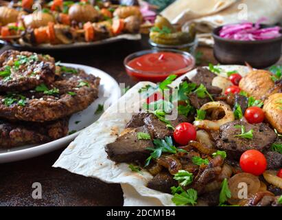 Spieße Leber, Vollgemüse und Pilze auf Spieße. Speisekarte vom Grill-Restaurant. Georgische, asiatische Küche. Verschiedene Gerichte Leberkebab. Stockfoto