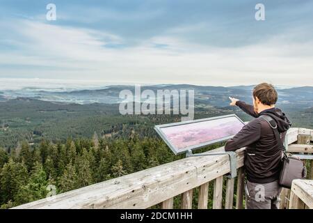 Mann auf Aussichtsturm Blick in einer Karte.Male Backpacker genießen Blick auf neblige Landschaft.man Traveler auf Böhmischen Berg Boubin.Reisen Stockfoto