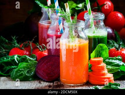 Gesunde Gemüse-Smoothie-Glasflaschen mit Strohhalmen, Vintage-Holzhintergrund, selektiver Fokus Stockfoto