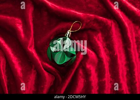 Grüne weihnachtsdekoration auf roten Samtwellen Hintergrund. Trendige Farben von 2021 Stockfoto