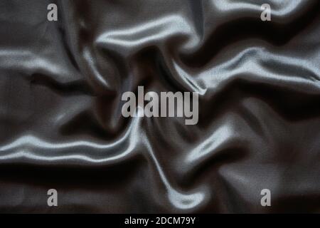 Falten schwarzen Satin Tuch Textur Hintergrund Stockfoto