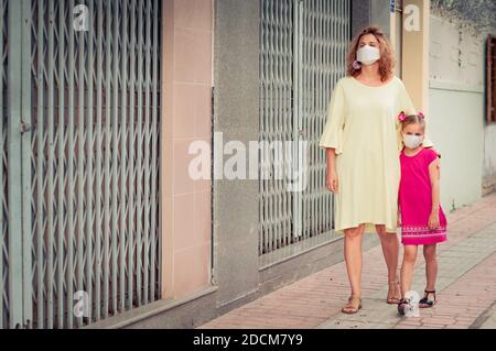 Frau und Tochter tragen eine Einwegmaske, um Virusinfektionen zu vermeiden. Schutz vor Coronavirus Stockfoto