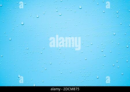 Wasser- oder Regentropfen auf blauem Plastikblechhintergrund Stockfoto