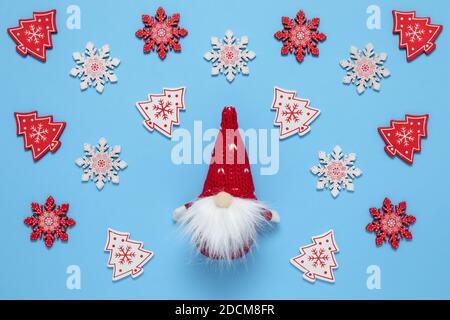 Weihnachtlicher Hintergrund mit einem Gnom in einem roten Hut in Form eines Kegels mit Bart. Winterschmuck, Kunstmuster. Geschenkkarte mit Weihnachtsmann. Neues Jahr Stockfoto