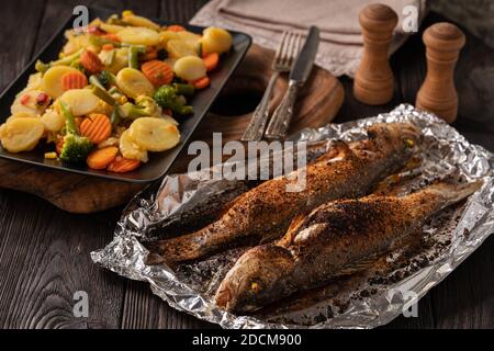 Hausgemachte gegrillte Labrax serviert mit geschmortem Gemüse. Stockfoto