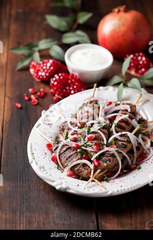 Gegrillte Hackfleischspieße Kebabs mit Zwiebeln, Sumac und Granatapfel, selektiver Fokus Stockfoto
