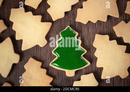 Draufsicht auf dekorierte grüne Ebene Geschmack Lebkuchen Weihnachtsbaum Cookie auf Holztisch Hintergrund mit Kopieplatz, Konzept der Feiertagsfeier. Stockfoto