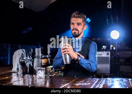 Bartender Barkeeper legt den letzten Schliff auf einen Drink an Der Nachtclub Stockfoto