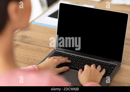 Lady arbeitet auf Laptop mit leeren schwarzen Bildschirm für mockup Stockfoto