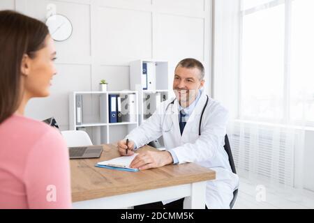 Lächelnder erfahrener Arzt im Gespräch mit seinem Patienten Stockfoto
