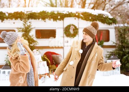 Schneekampf. Fröhliche Millennial Paar Spaß, Schneekugeln auf einander werfen Stockfoto