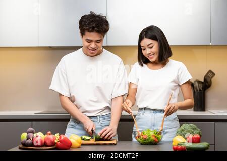Happy Chinese Ehepartner Kochen Zusammen In Küche Zu Hause Stockfoto