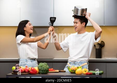 Japanisch Familie Fechten Mit Kochwerkzeugen Mit Spaß In Der Küche Stockfoto