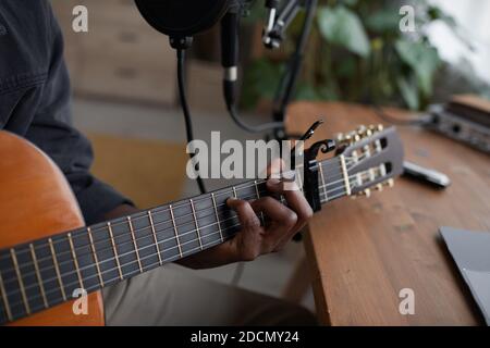 Nahaufnahme eines jungen afroamerikanischen Mannes, der Gitarre im heimischen Aufnahmestudio spielt, Kopierraum Stockfoto