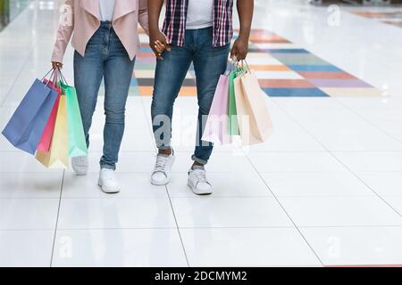 Konsumdenken. Unkenntlich Schwarzes Paar Zu Fuß Mit Bunten Einkaufstaschen In Der Mall Stockfoto