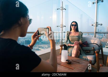 Frau Mädchen Freunde, die Fotos in der High-View-Café bei Sonnenuntergang. Weibliche Freundschaft und Spaß Zeit abstrakt Stockfoto