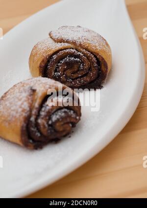 Köstliche Kakaoschnecken auf einem weißen Teller Closeup Stockfoto