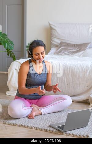 Ältere Frau mit Kopfhörern bereitet sich auf das Training im Internet vor. Sie sucht im Internet nach Übungsvideos. Stockfoto
