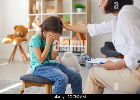 Kleines Mädchen weint im Büro des Psychotherapeuten, das Probleme und Bedenken teilt Und Hilfe suchen Stockfoto
