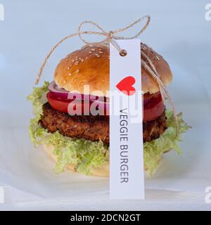 Hausgemachter vegetarischer Hamburger auf einem Olivenholzbrett, Nahaufnahme, ein Schild, das ich VEGGIE BURGER LIEBE Stockfoto