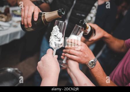 Eine Nahaufnahme der schönen Füllung in ihre Gläser mit Champagner zum Gratulieren des Paares Stockfoto
